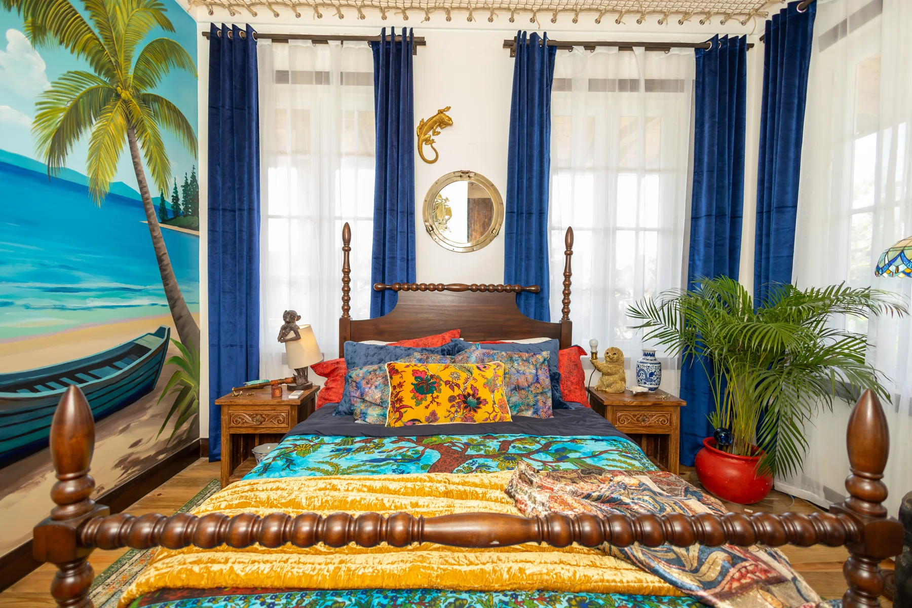 Captain’s Quarters bed beneath a hand-painted island mural