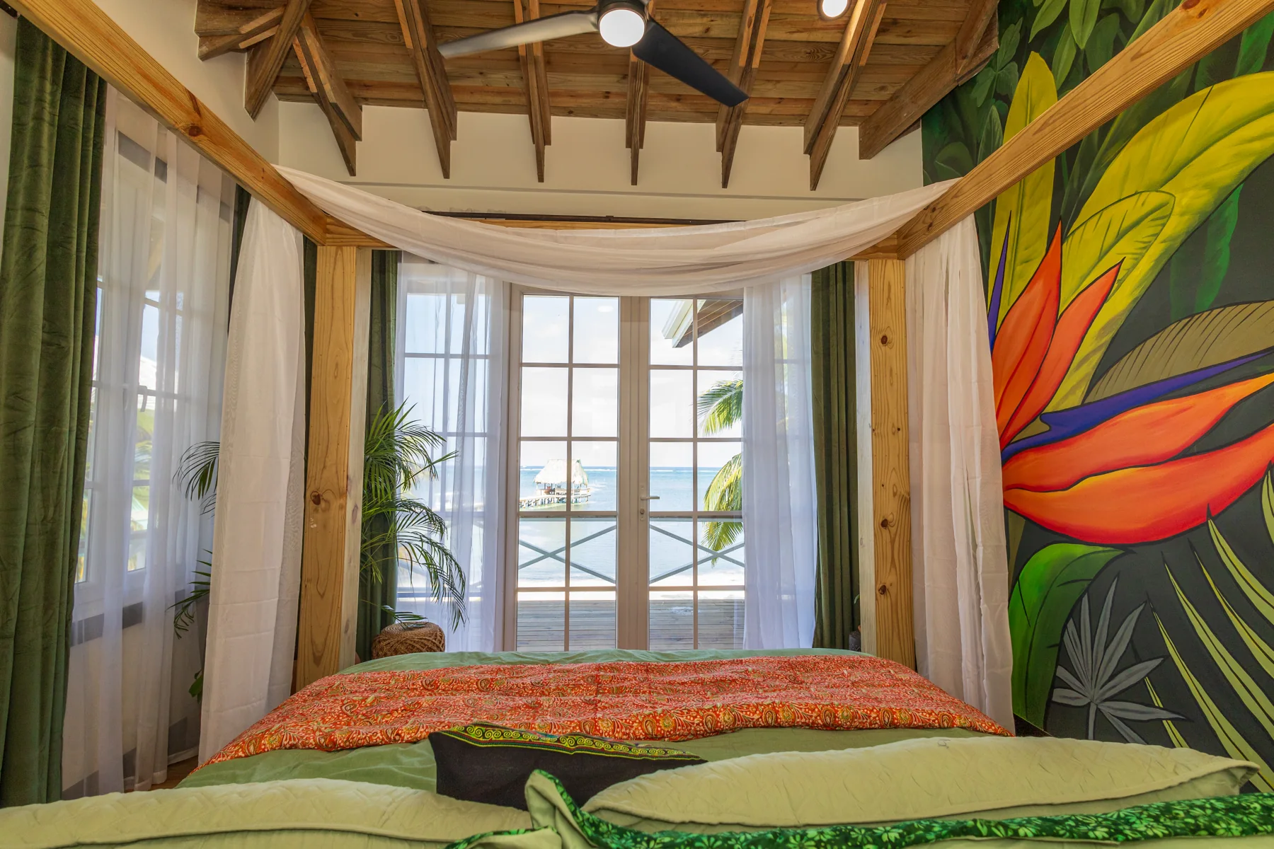 Jungle Room bed facing glass doors and tropical mural
