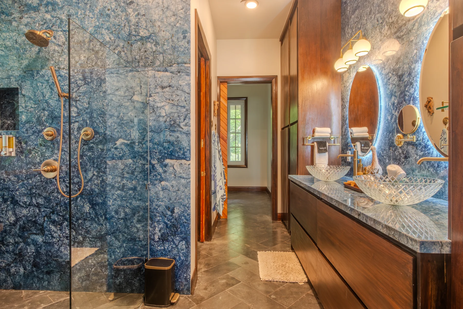 Blue stone walls, shower, and double vanity in the Ocean Room bathroom