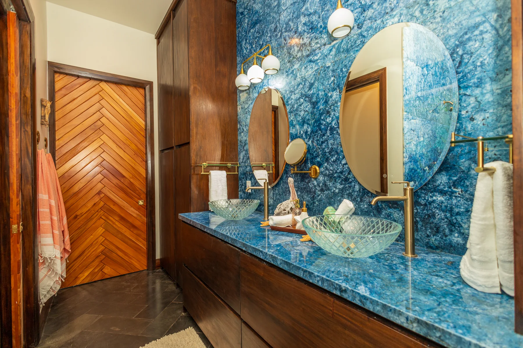 Ocean Room bathroom vanity with glass vessel sinks and round mirrors