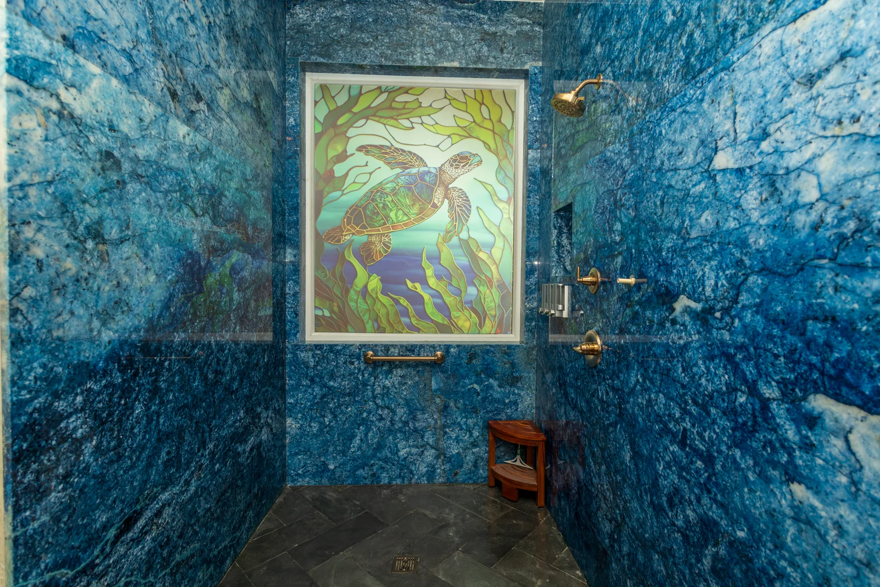 Ocean Room shower surrounded by blue stone walls
