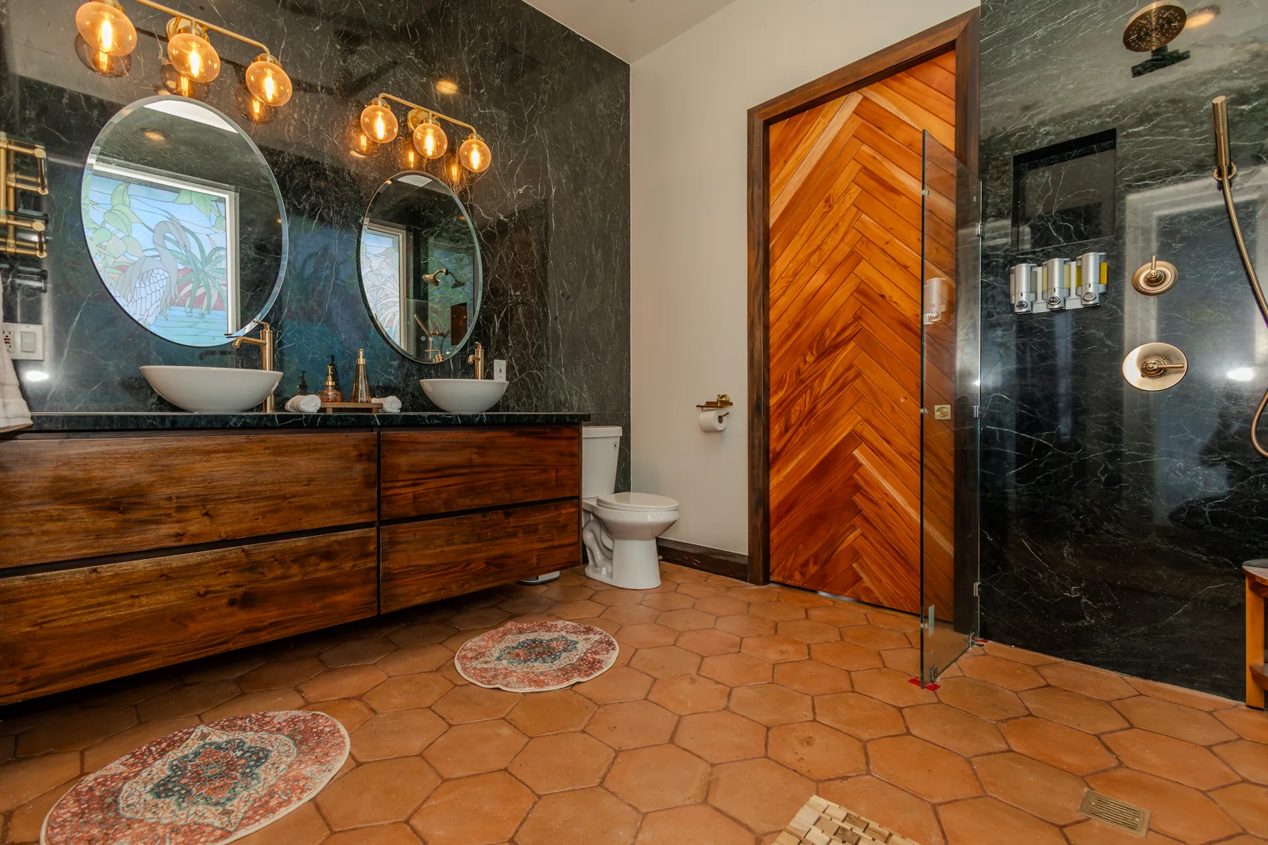 Shared green-stone bathroom with double vanity and toilet